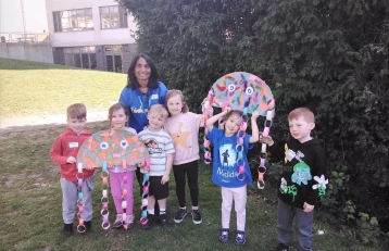 Early Years Manager with children and their art projects